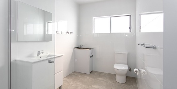 An all white modern bathroom with clean finishes, representing a stylish granny flat bathroom design.